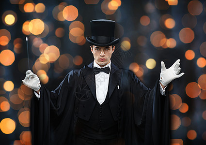 表演,马戏,表演魔术师顶帽斗篷展示魔术棒近光灯背景图片