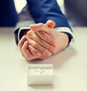 人,同婚姻爱情亲密的快乐男夫妇牵手结婚戒指盒子桌子上图片