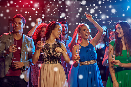 新派,假期,庆祝,夜生活人们的微笑的朋友俱乐部雪的效果中碰杯含酒精的香槟啤酒图片