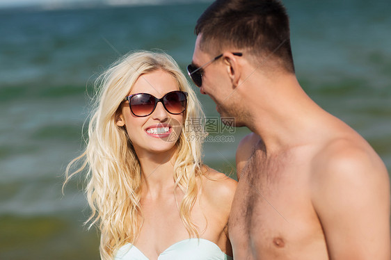 爱情,旅行,旅游,夏天人的微笑的夫妇度假时穿着泳装太阳镜,牵着手海滩上散步图片