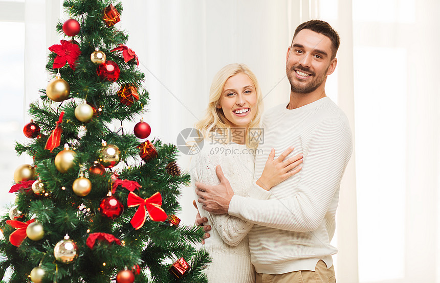 家庭,诞节,寒假人们的幸福的夫妇拥抱诞树附近家图片