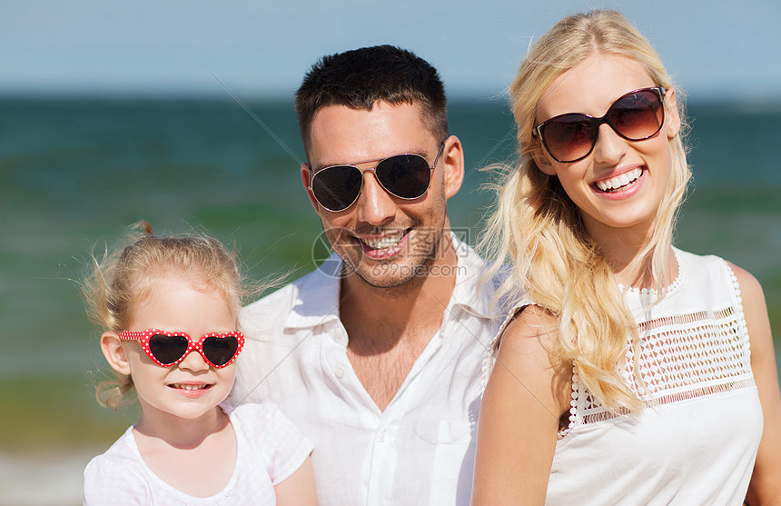 家庭,假期,收养人的快乐的男人,女人小女孩戴着太阳镜夏天的海滩图片