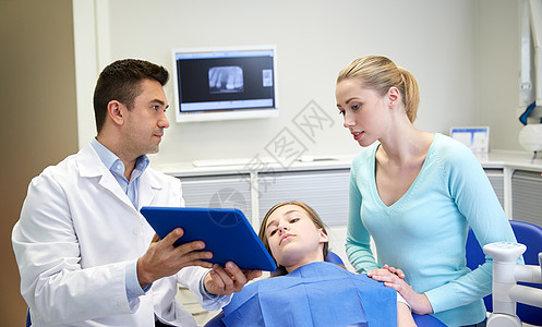 人,医学,口腔医学,技术保健男牙医平板电脑电脑给病人女孩她的母亲牙科诊所办公室图片