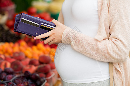 与市场净土销售,购物,怀孕人们的密切孕妇与钱包信用卡购买食品街头市场背景