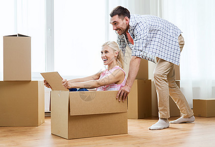 家,人,移动房地产的幸福的夫妇玩得开心,骑纸板箱新的家图片