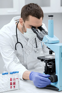 科学,医学,技术,生物学人的轻的男科学家,试管看显微镜制造研究临床实验室图片