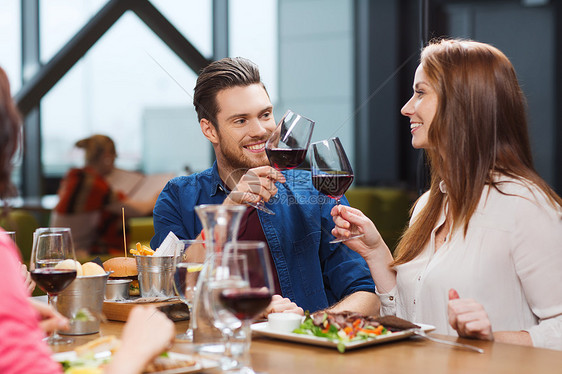 休闲,饮食,食物饮料,人假日的微笑的夫妇餐厅吃饭喝红酒图片