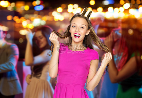 人,假日,庆祝魅力快乐的轻妇女少女穿着粉红色的衣服公主皇冠夜总会聚会上的人群灯光背景图片