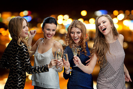 庆祝,朋友,单身派,夜生活假期快乐的女人碰着香槟酒杯,夜灯背景上跳舞背景图片