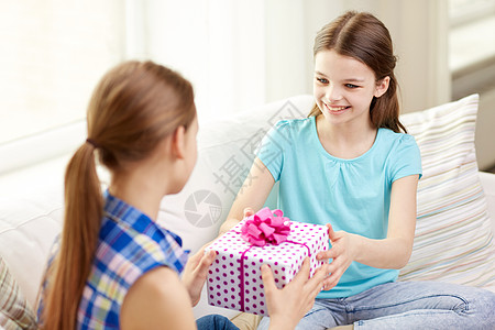 人,孩子,假期,朋友友谊的快乐的小女孩生日礼物坐家里的沙发上图片