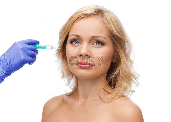 美容,抗衰容手术的女部美容师手配合注射器注射脸颊图片