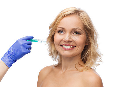 美容,抗衰容手术的微笑的女人脸美容师携手手套与注射器注射脸颊图片