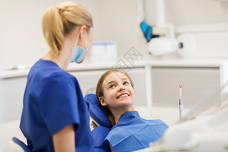 人,医学,口腔科保健快乐的女牙医与病人女孩牙科诊所办公室交谈图片