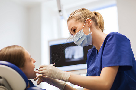 人,医学,口腔科保健快乐的女牙医用镜子牙科探头检查病人女孩的牙齿牙科诊所办公室图片