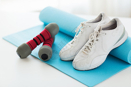 运动,健身,健康的生活方式物品的运动鞋,哑铃运动垫图片