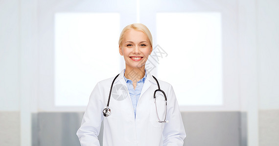 医疗保健,职业,人医学微笑的女医生穿着白色外套,带听诊器医院背景下图片