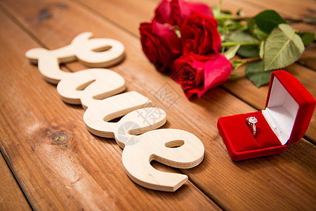 求婚,浪漫,情人节假期的礼品盒与钻石订婚戒指,红色玫瑰字爱的木材图片