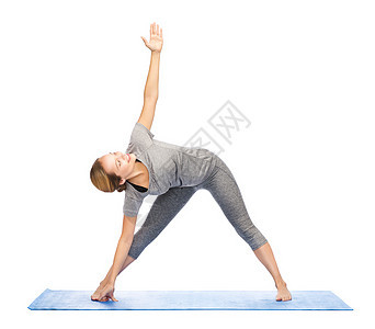 健身,运动,人健康的生活方式女人瑜伽三角姿势垫子上图片