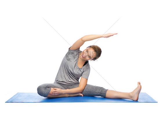 健身,运动,人健康的生活方式快乐的女人瑜伽伸展垫子上图片
