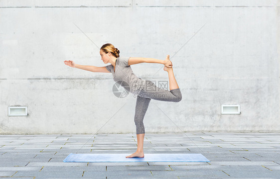 健身,运动,人健康的生活方式女人瑜伽舞蹈的主人垫子上的城市街道背景图片