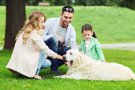 家庭,宠物,家畜人的快乐的家庭与拉布拉多猎犬夏季公园散步图片