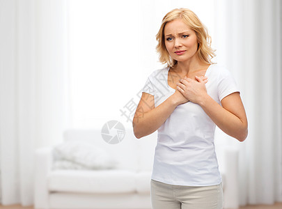 人,医疗,心脏病问题的快乐的女人遭受心痛的客厅背景图片