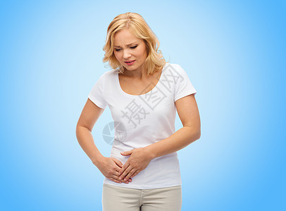 人,医疗保健问题幸的女人患胃痛的蓝色背景图片