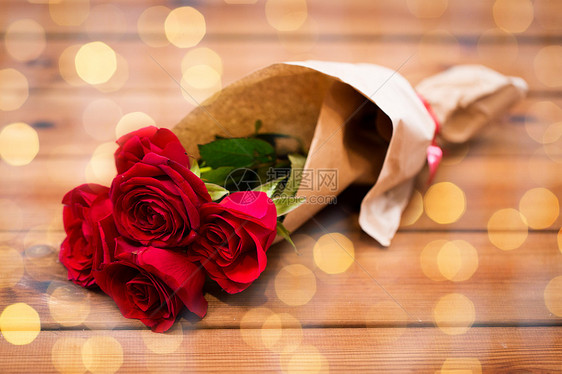 爱情,约会,鲜花,情人节假期的红色玫瑰包裹成棕色的纸木桌上图片