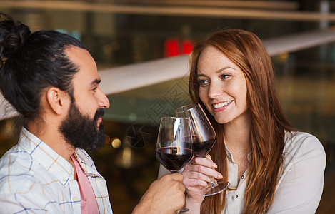 休闲,饮食,食物饮料,人假日的微笑的夫妇庆祝周纪念餐厅碰红酒杯背景图片