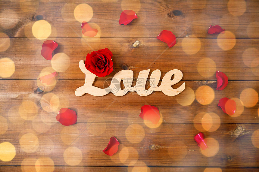 爱情,约会,浪漫,情人节假期的文字爱与红色玫瑰花瓣木材上的金色灯光图片