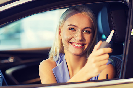 汽车业务,汽车销售,消费主义人们的快乐的女人经销商的汽车钥匙车展沙龙图片