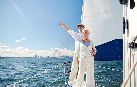 航海,龄,旅游,旅行人们的快乐的老夫妇指着漂浮海上的帆船游艇甲板上的东西图片