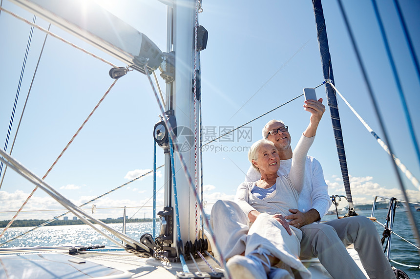 航海,技术,旅游,旅游人的快乐的老夫妇与智能手机自拍帆船游艇甲板漂浮海上图片