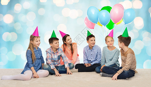童,假期,友谊人的快乐的微笑孩子生日蓝色假日灯光背景上戴着派帽图片