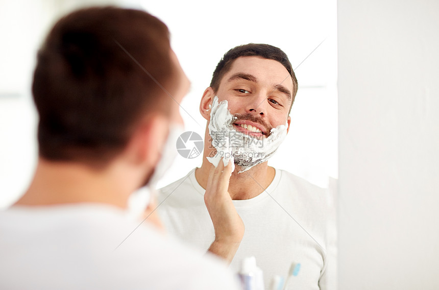 ‘~美容,卫生,剃须,美容人们的微笑的轻人看着镜子,家里的浴室里用剃须泡沫  ~’ 的图片