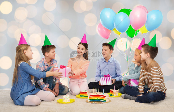 童,假期,庆祝,友谊人的快乐的微笑孩子派帽子与蛋糕送礼物生日聚会上的灯光背景图片