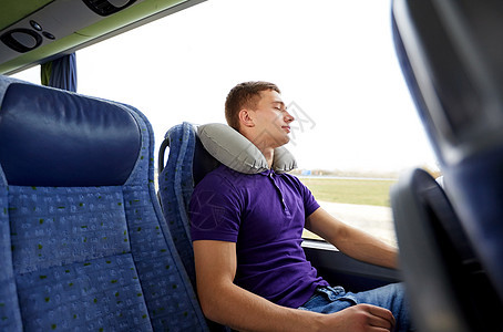 交通旅游公路旅行休息人的快乐的轻人睡带充气枕头的旅游巴士上图片