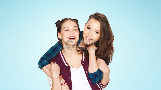 人,朋友,青少友谊的快乐的微笑,漂亮的十几岁的女孩拥抱蓝色的背景图片