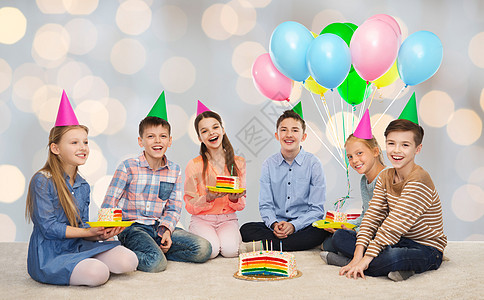 童,假期,庆祝,友谊人的快乐的微笑孩子戴着生日蛋糕气球灯光背景上的派帽图片
