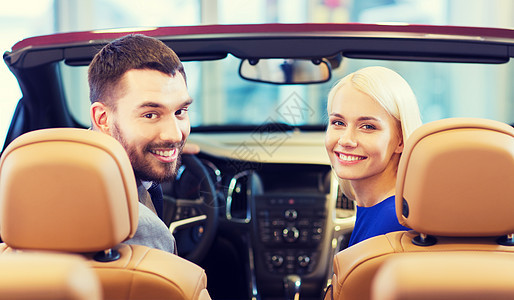 汽车业务,汽车销售,消费主义人们的幸福的夫妇坐汽车展览沙龙图片