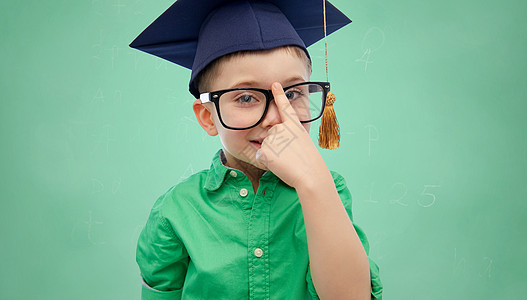 童,学校,教育,知识人的快乐的男孩学士帽灰泥板眼镜上的绿色学校粉笔板背景图片