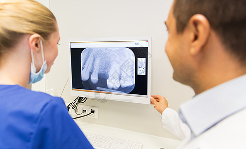 人,医学,口腔科保健的牙医助理看X射线监测屏幕上的牙科诊所图片