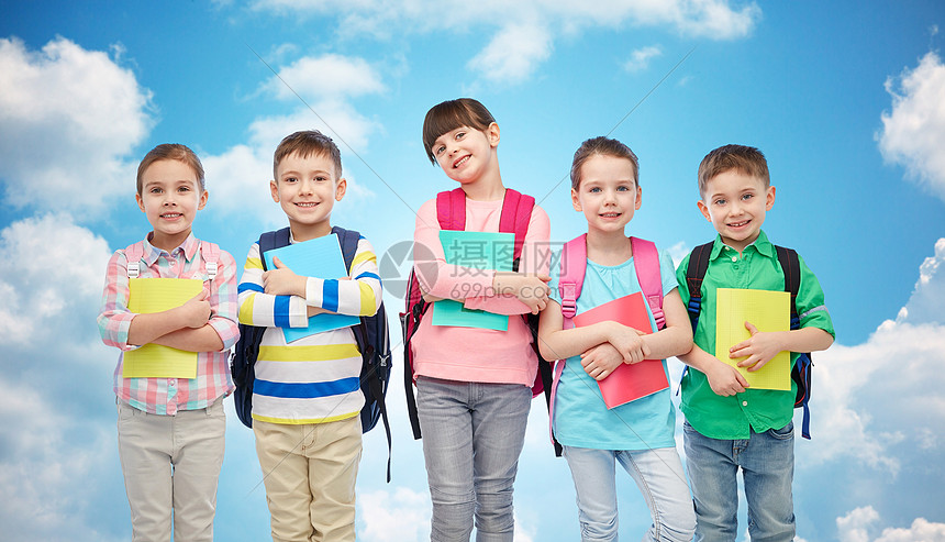 童,学前教育,学人的群快乐微笑的小孩子,书包笔记本蓝天云彩的背景上图片