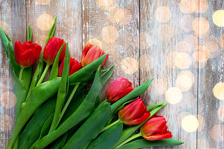 园艺,花卉,广告假日红色郁金香木制背景上的灯光图片