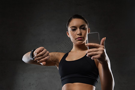 体育,健身,技术人的轻的女人与心率手表智能手机健身房图片