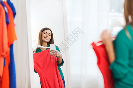 服装,时尚,风格,技术人的快乐的女人与智能手机SND红色连衣裙采取镜子自拍家衣柜图片