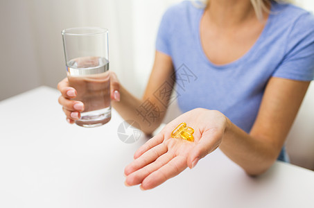 健康饮食,药物,保健,食品补充剂人的密切妇女手药丸鱼油胶囊水璃家里图片