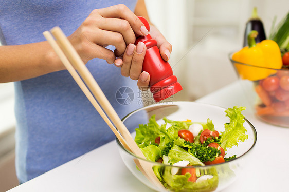 健康饮食,素食,烹饪人们的密切轻妇女调味蔬菜沙拉与盐胡椒家里图片