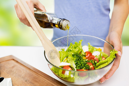 健康饮食,素食,饮食人们的近距离的轻妇女敷料蔬菜沙拉与橄榄油绿色的自然背景图片