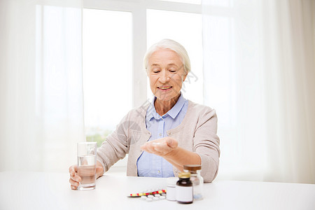 龄,医学,保健人的快乐的老妇女家里吃药喝水图片